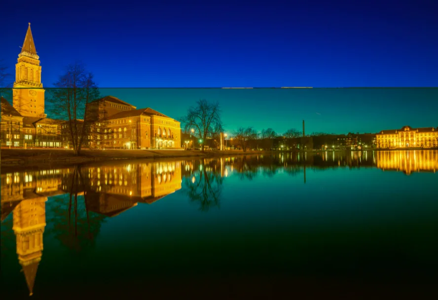 The town hall and the opera house at night, reflected in the Kleiner Kiel