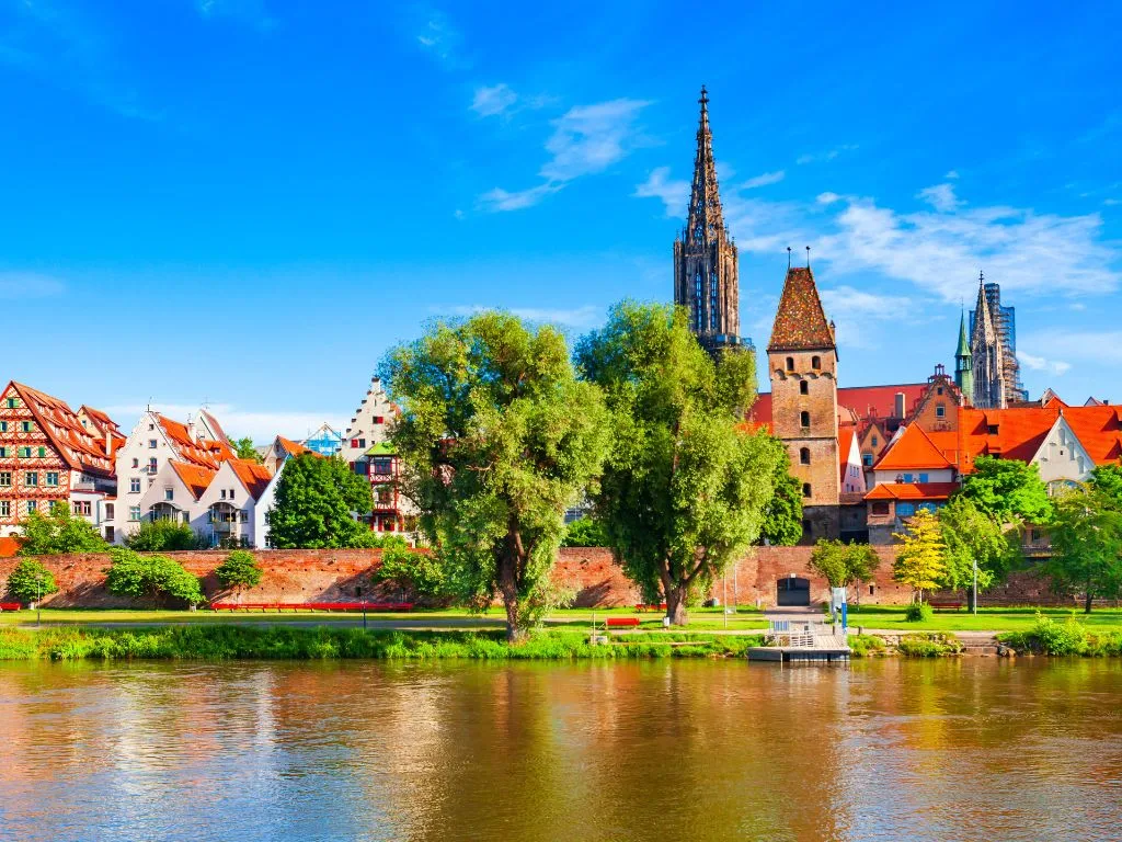 Ulm vom Donauufer aus mit dem Turm des Münsters und dem Metzgerturm über der Stadtmauer