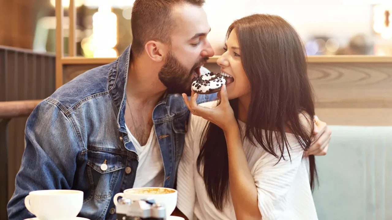 An escort couple sharing a cupcake