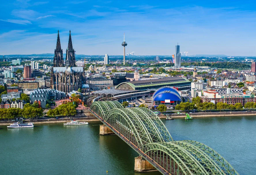 Cologne cathedral and the Hohenzollernbrücke over the Rhine, from the far bank