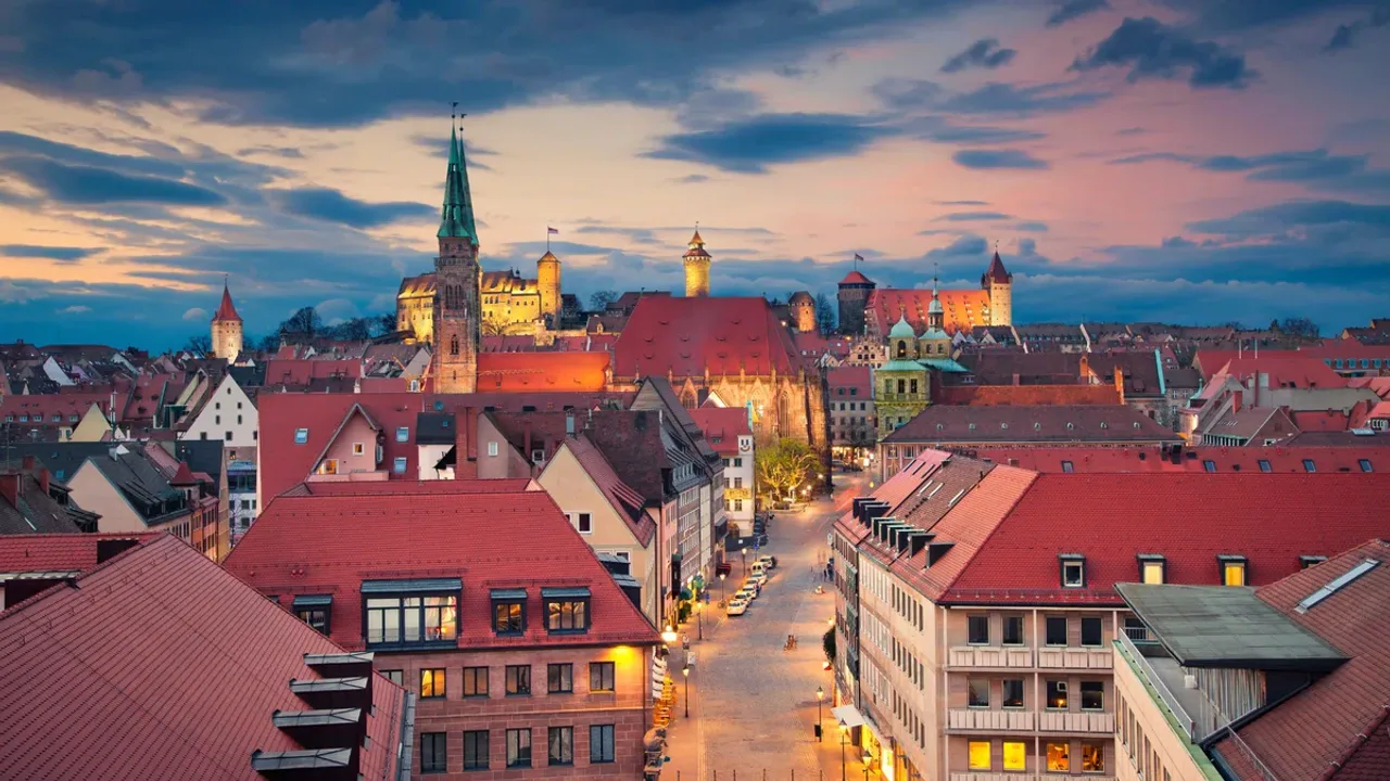 The roofs of the Nuremberg old town at sunset, behind them the Kaiserburg