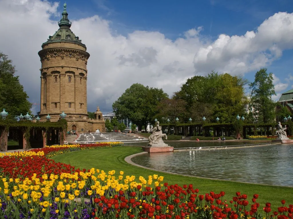 Der Wasserturm hinter Tulpenbeeten, daneben die Brunnenanlage des Friedrichsplatzes