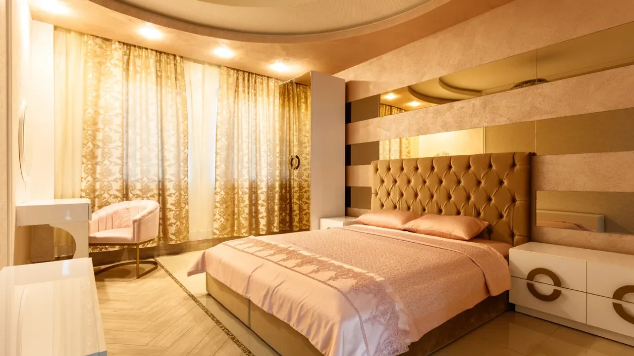 A hotel room with the bed turned down and two glasses on the nightstand