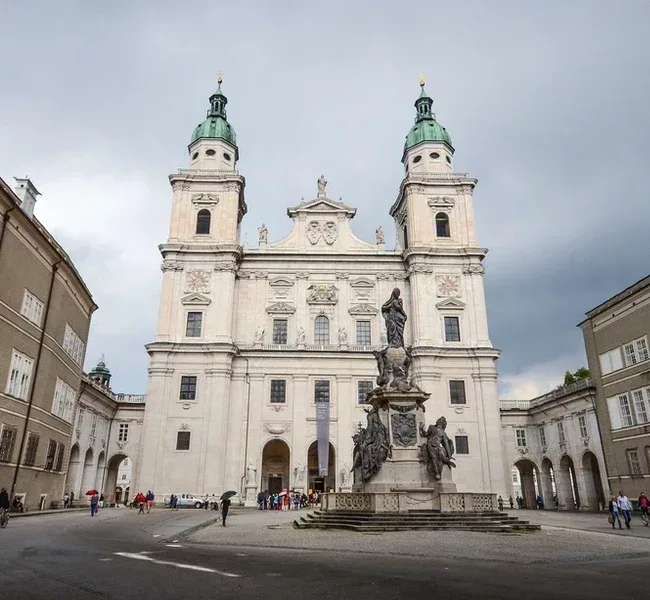 The baroque facade of Salzburg Cathedral on the Domplatz with the Marian column in front of it