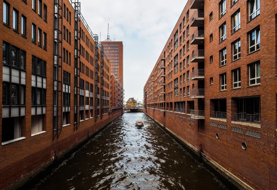 Ein Fleet zwischen den Backsteinspeichern, eine Barkasse in der Mitte des Kanals