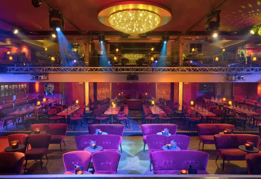 The GOP hall with laid tables, a chandelier and spotlights over the stage