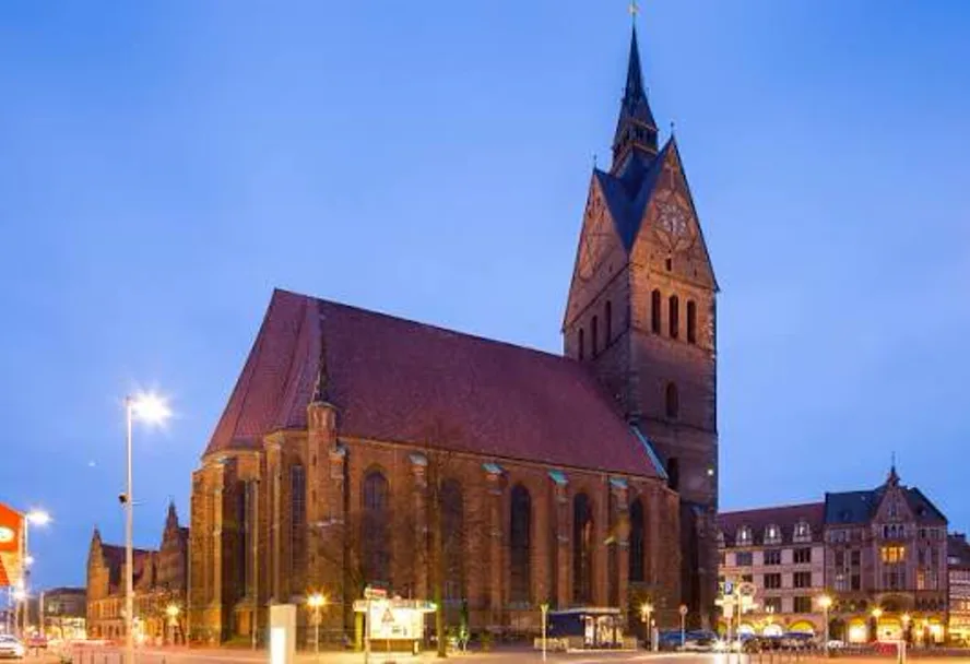 The red-brick Marktkirche at dusk, its tower lit