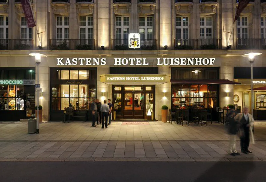 The lit facade of Kastens Hotel Luisenhof in the evening
